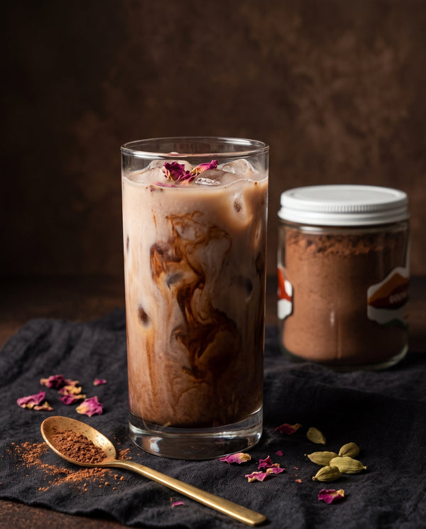 Iced cardamom, rose and ginger cocoa in a tall glass with dried rose petals