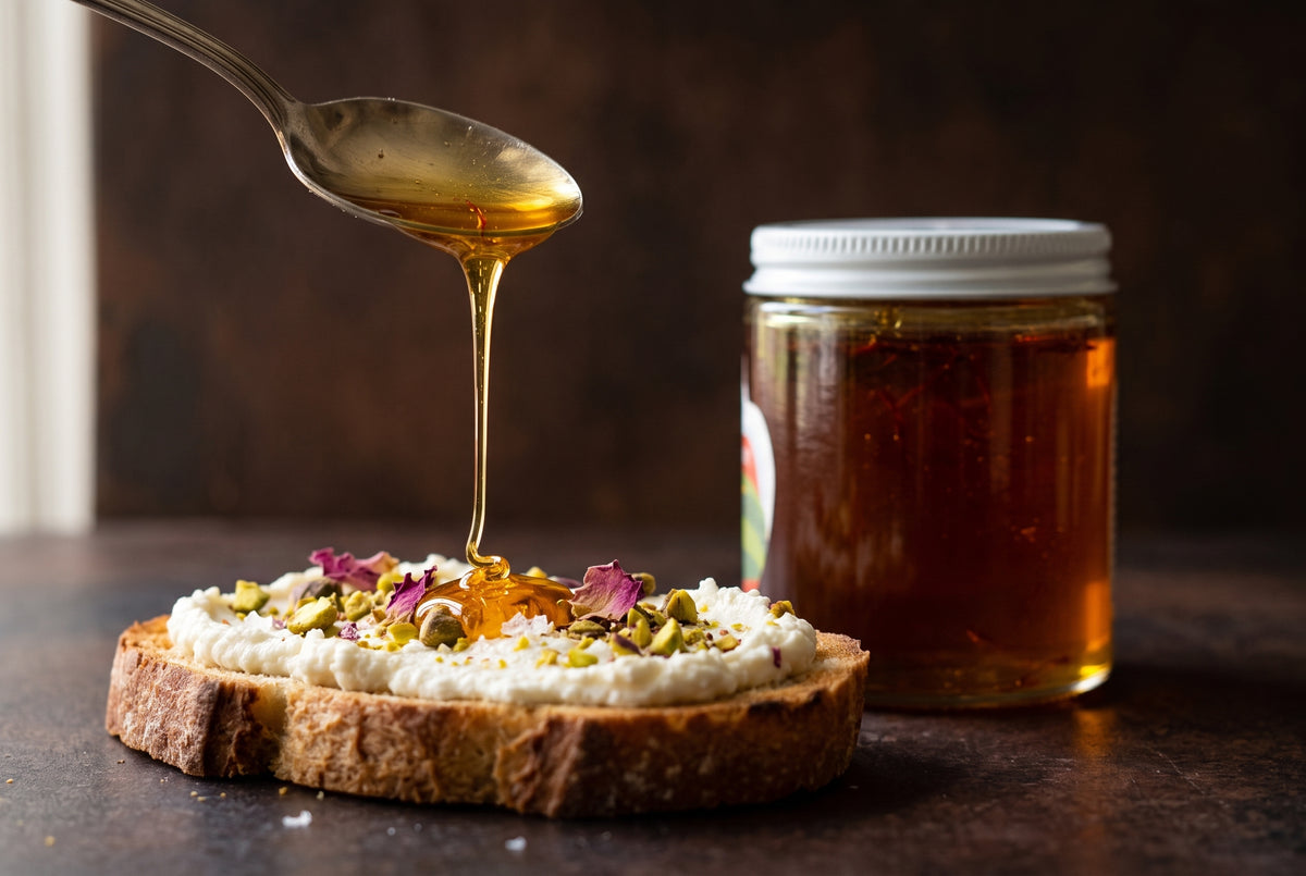 Saffron honey drizzling from a spoon onto ricotta toast